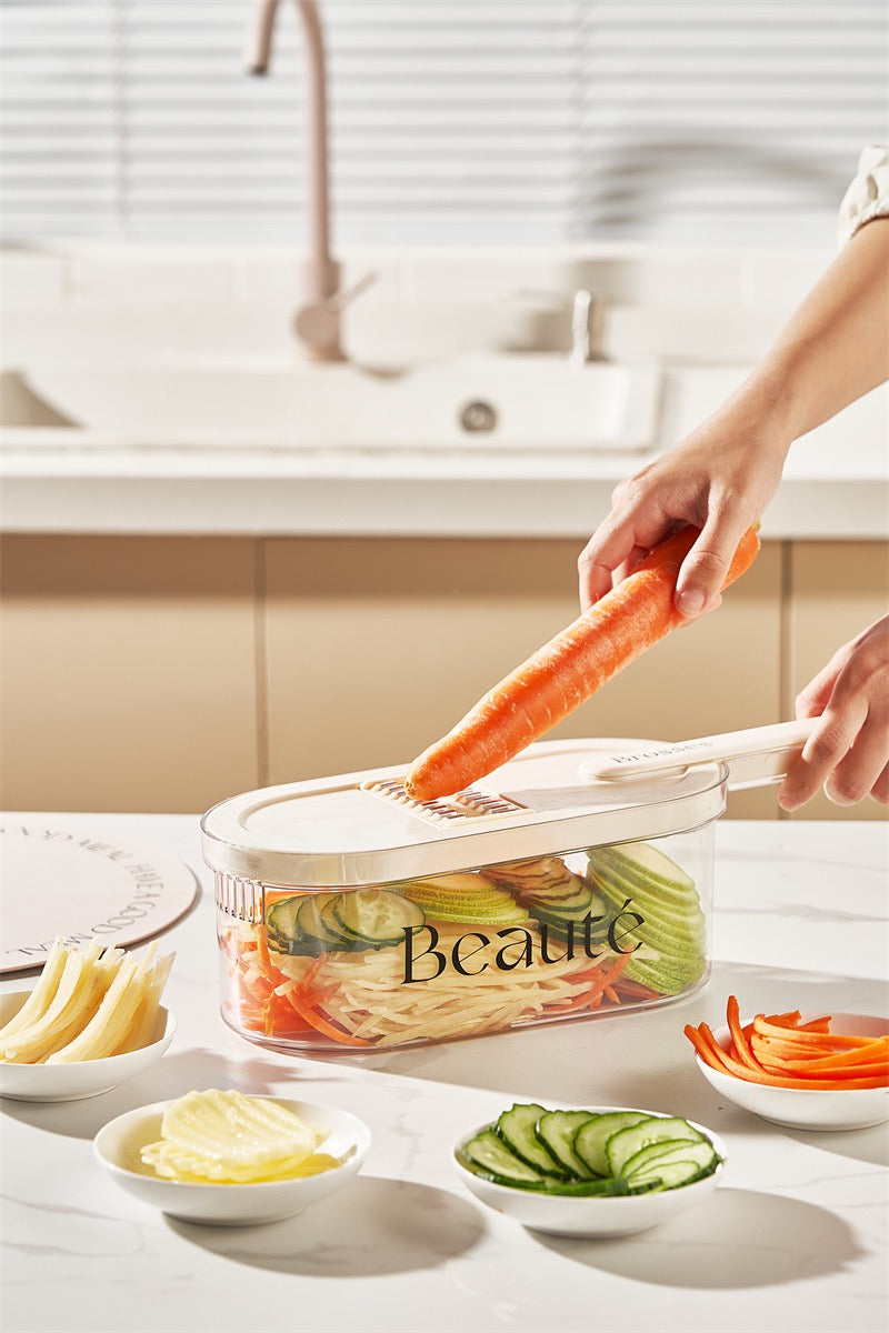 Person using a vegetable peeler to slice carrots on a kitchen counter with various sliced vegetables.
