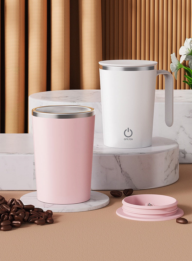 Two mugs, one pink and one white with a power symbol, on marble stands with coffee beans and a small plant.