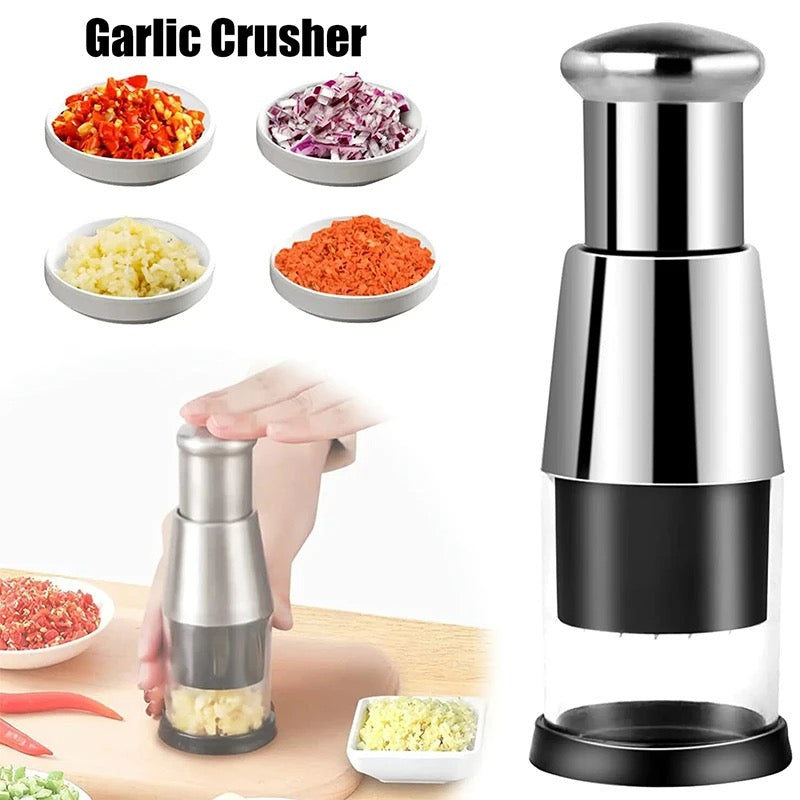 Garlic crusher with garlic, onion, and carrot samples on a white background