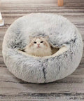 Cat lying in a fluffy gray pet bed on a striped carpet