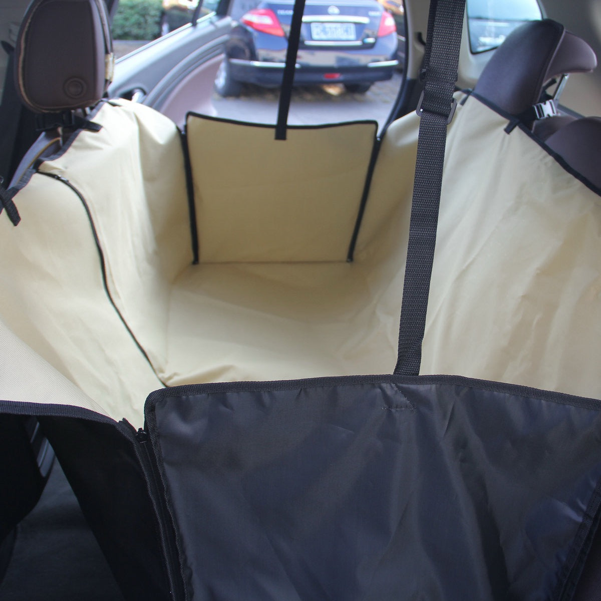 Car seat cover in a vehicle with a visible car outside through the window.