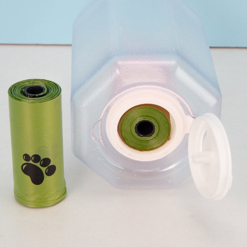 Green roll of dog waste bags with a clear plastic bag dispenser on a light blue background